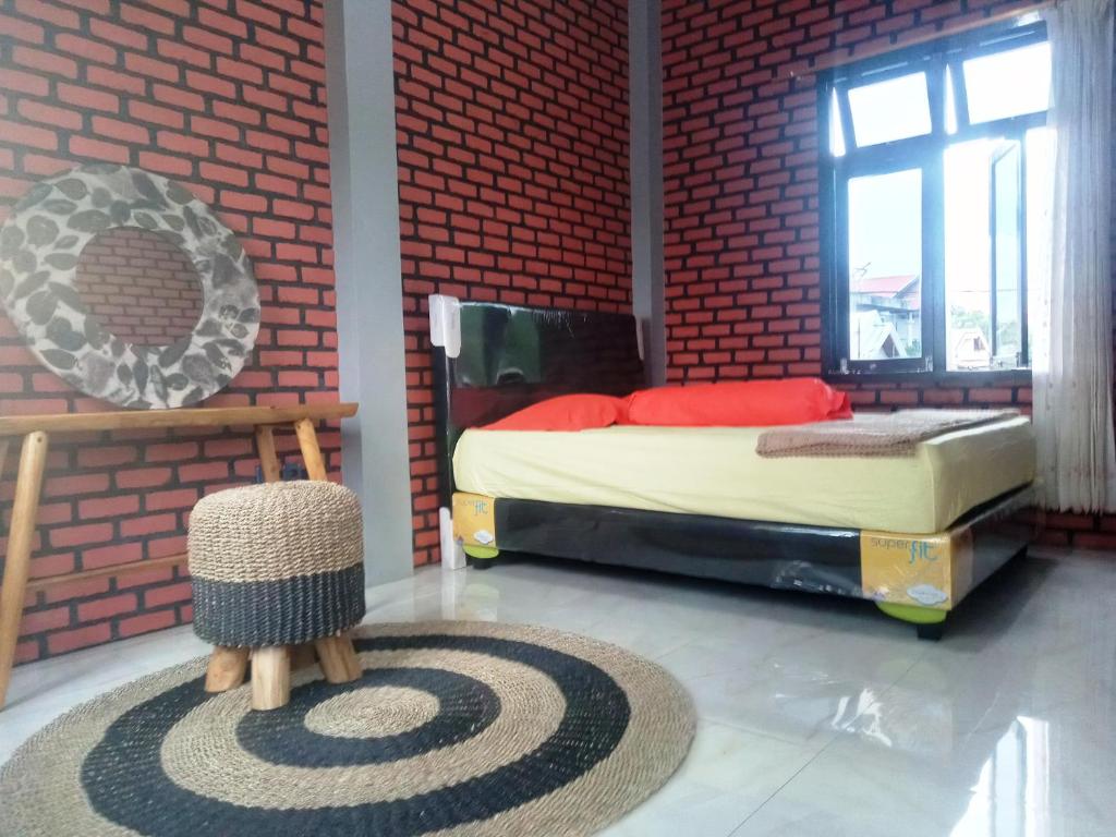 特尔纳特岛古妮亚民宿的一间卧室设有一张床和红砖墙