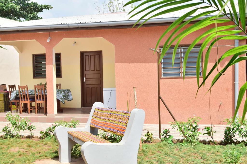 科托努Akwa Guesthouse Cotonou的坐在房子前面的长凳