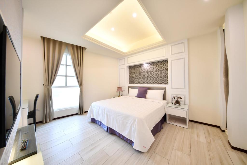 马公传承堡大饭店的卧室配有白色的床和窗户。