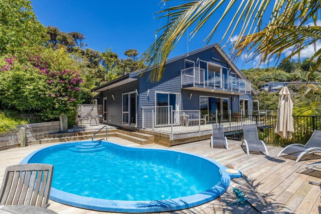 WhangaroaHarbour View的一座带游泳池和房子的度假屋