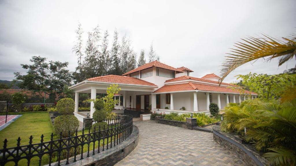 哥印拜陀SR Jungle Resort的前面有栅栏的白色房子