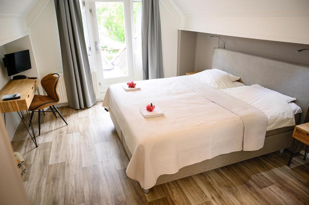 博尔讷亚克洛斯特酒店的卧室配有一张白色大床,床上有两朵鲜花
