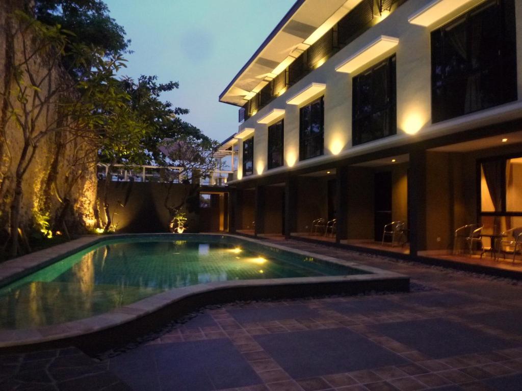 努沙杜瓦白色岩石旅馆的一座游泳池,在晚上在建筑物前