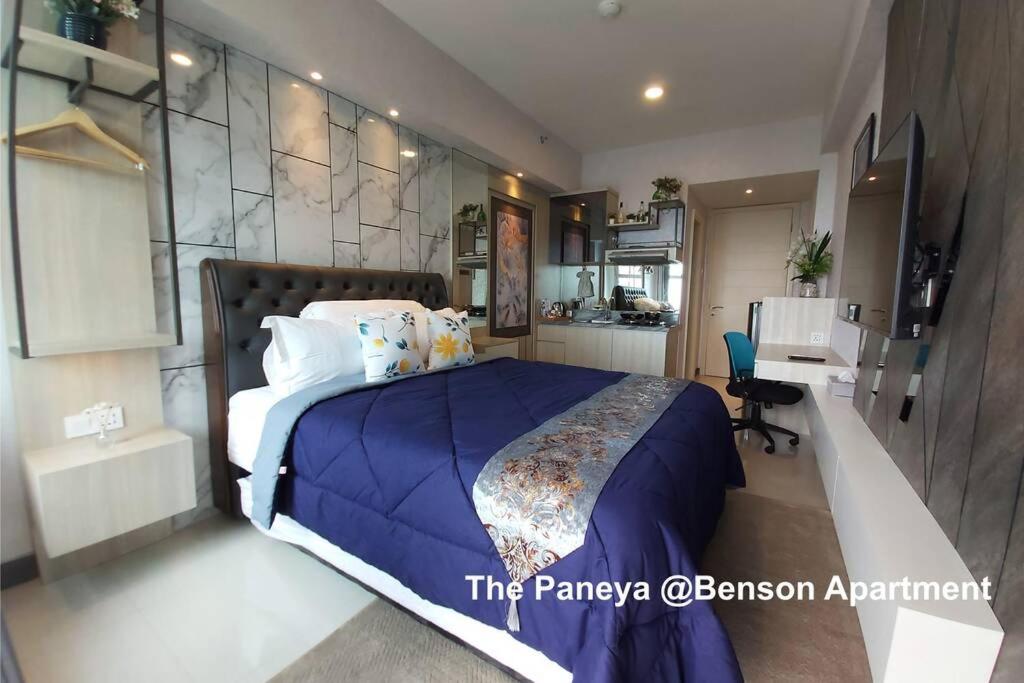 泗水The Paneya @Benson Apartment的一间卧室配有一张带蓝色毯子的大床