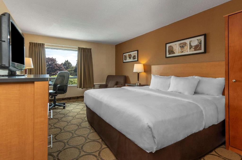帕里桑德Comfort Inn Parry Sound的酒店客房设有一张大床和一台电视。