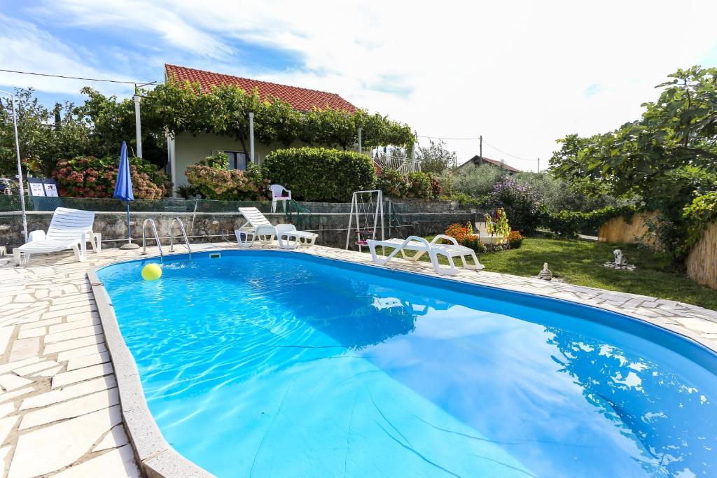 莫鲁纳特Villa Desin的一个带椅子的游泳池以及一座房子