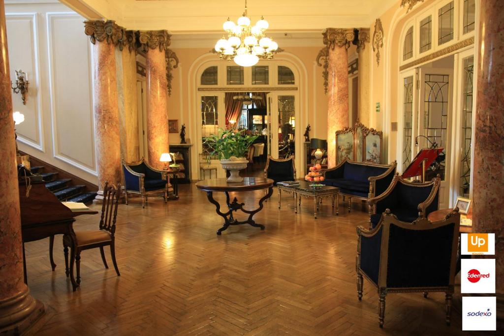 布加勒斯特格兰德精品酒店的客厅配有椅子、桌子和吊灯。