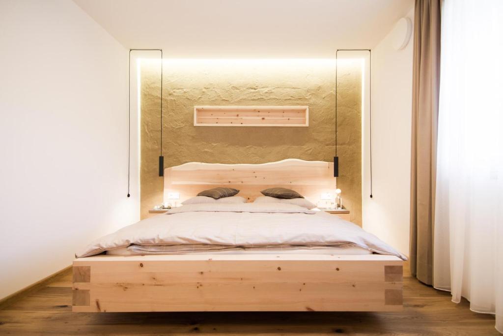 巴比亚诺haus urban B&B的一间卧室配有一张木床,上面有镜子