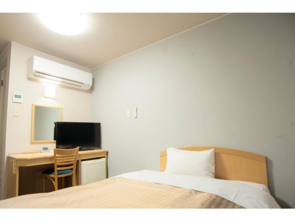 藤枝Fujieda Ogawa Hotel - Vacation STAY 20859v的一间卧室配有一张床和一张带电脑的书桌