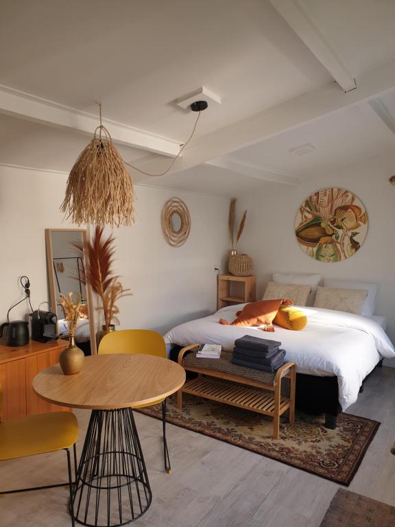 诺德韦克Little Lodge Noordwijk aan Zee的卧室配有一张床和一张桌子及椅子