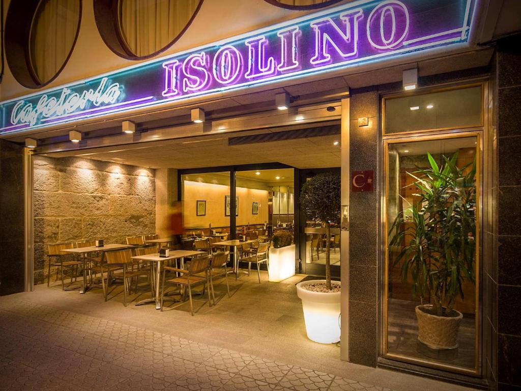 格罗韦伊索利诺酒店的前方设有桌子和 ⁇ 虹灯标志的餐厅