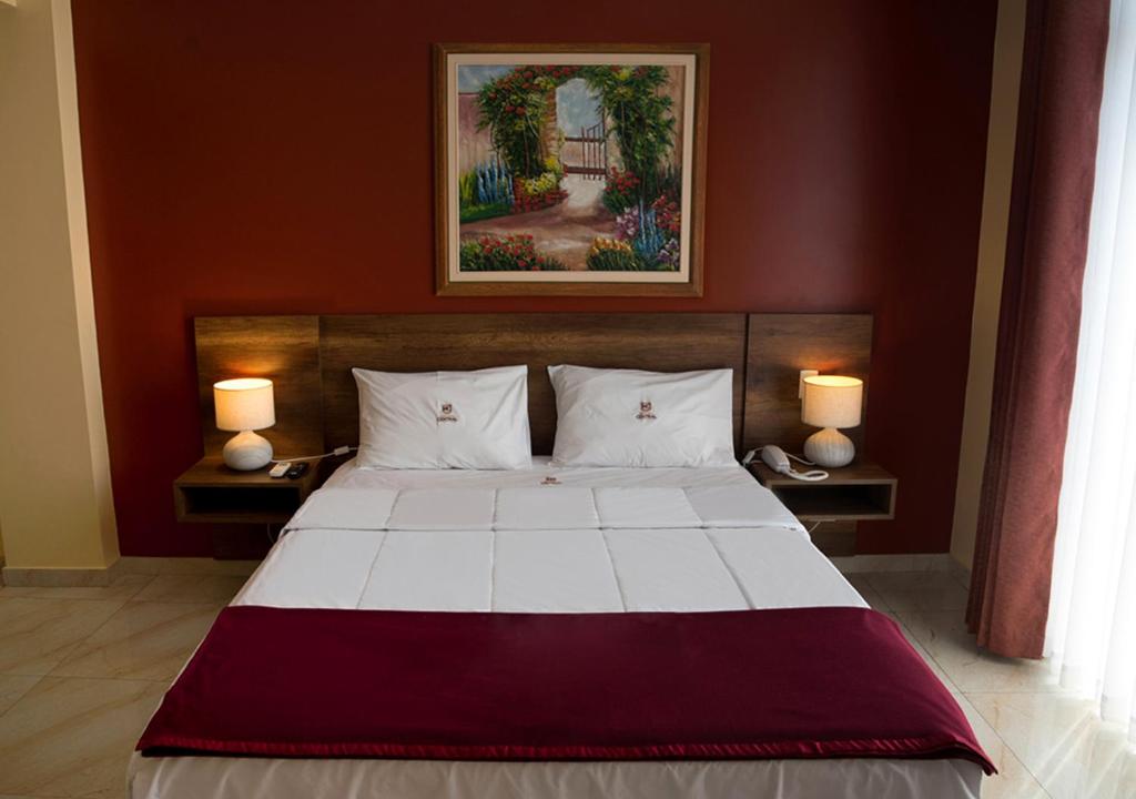 特鲁希略Hotel Central的一间卧室配有一张大床和两盏灯