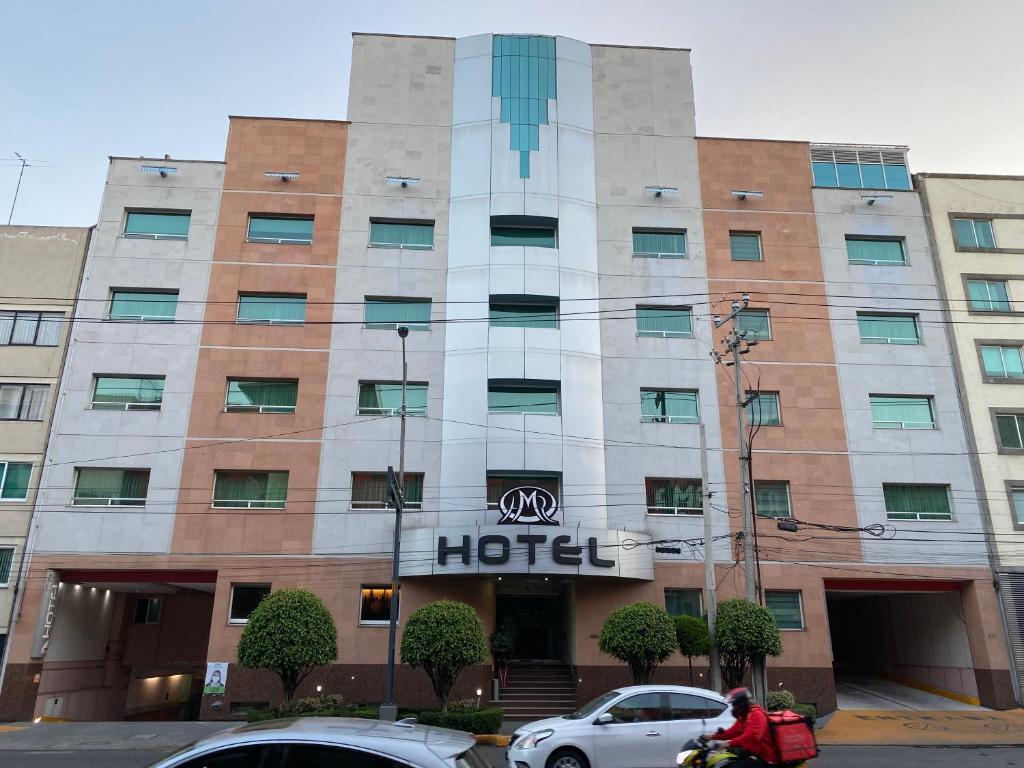 墨西哥城HOTEL MARIA RICO的门前有车辆停放的酒店