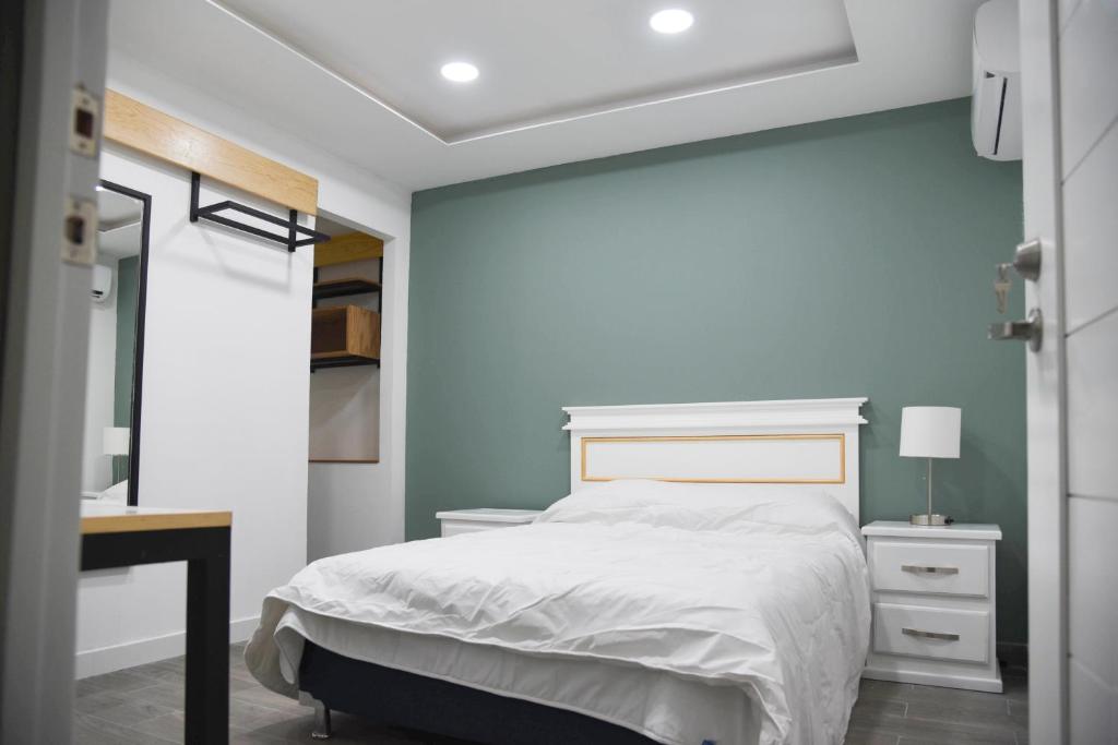 蒙特雷Casa moderna equipada como hotel Habitación 1的卧室配有白色的床和书桌