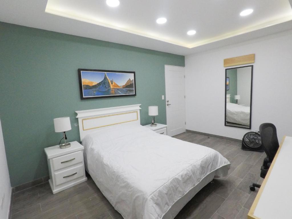 蒙特雷Casa moderna equipada como en pequeño hotel hab 4的卧室配有白色的床和绿色的墙壁