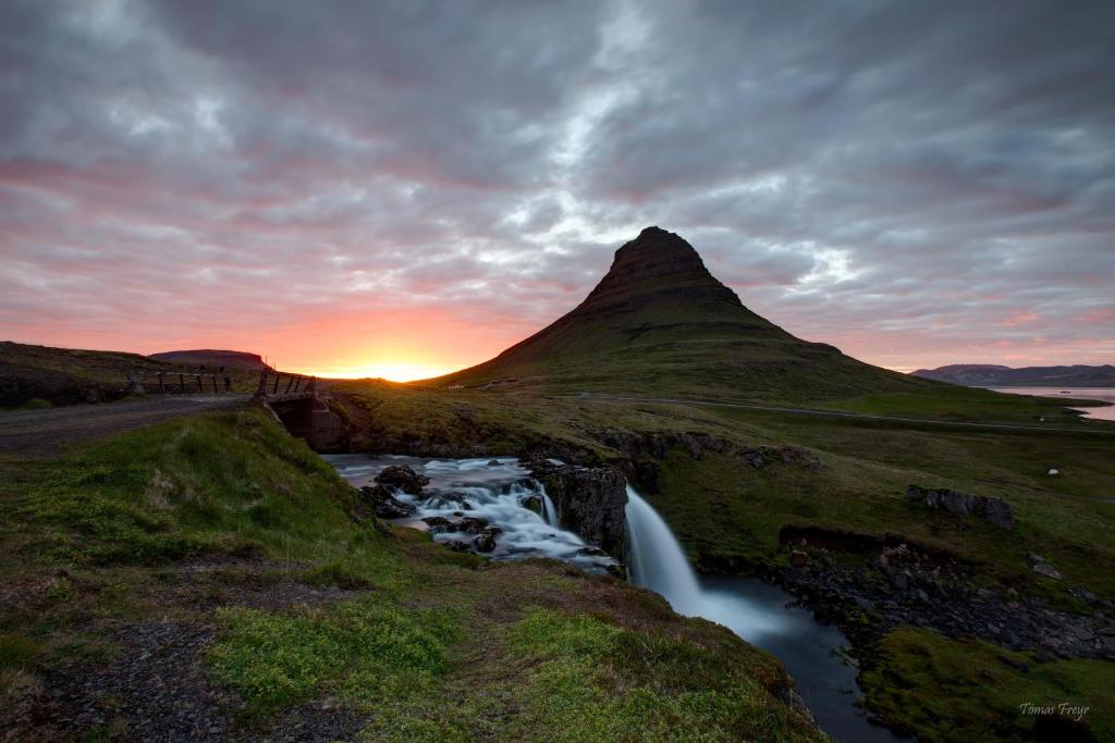 格仑达积图Búlandshöfði í Grundarfirdi的山上与河流的日落