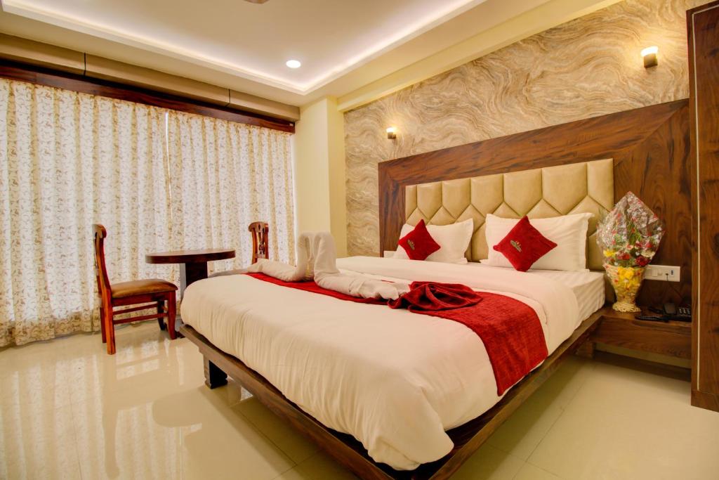 DiveHotel Samaira Residency,Dombivali的一间卧室配有一张大床和一张书桌