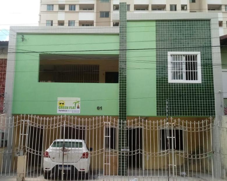 福塔莱萨Green Flat Fortaleza的停在绿色建筑前面的汽车