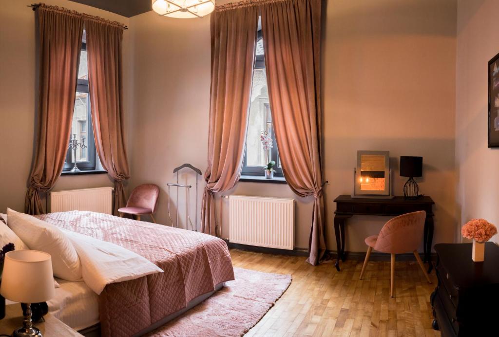 别尔斯克-比亚拉Apartament Podcienie z tarasem Bielsko-Biała Old Town的卧室配有一张床、一张书桌和窗户。