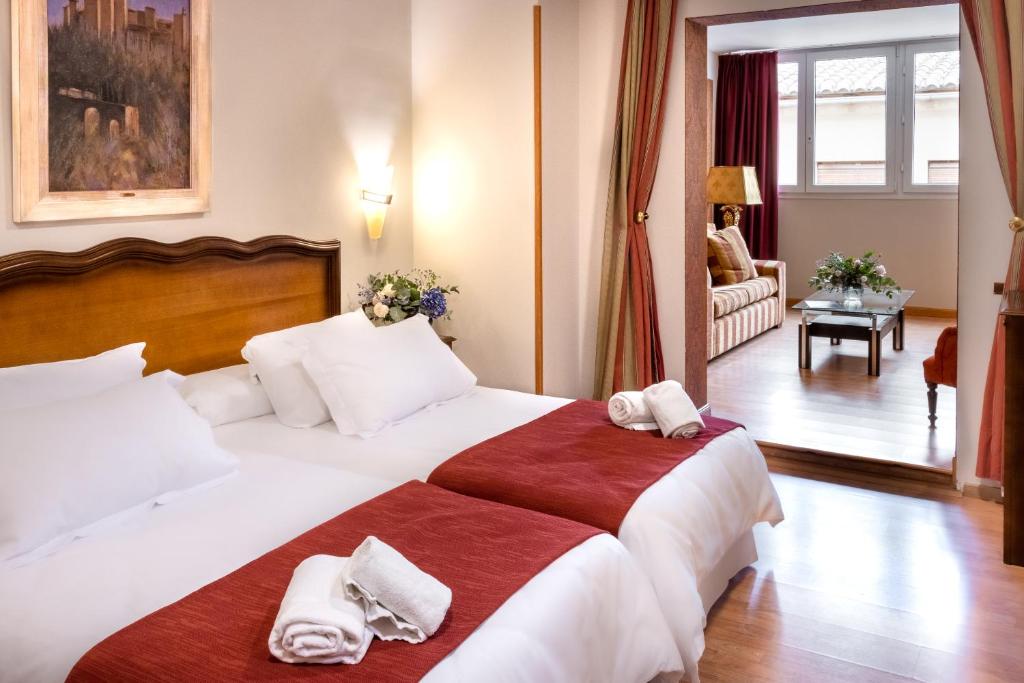 格拉纳达Hotel Reina Cristina的酒店客房带一张大床,带毛巾