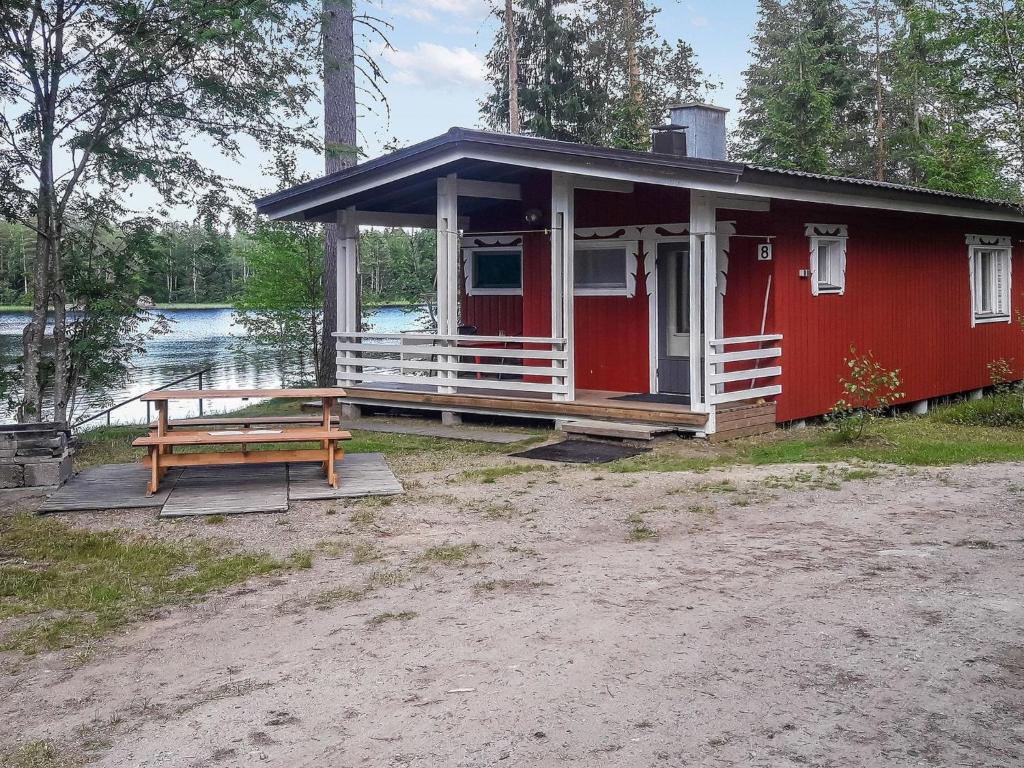 JuhanalaHoliday Home Mäntylä by Interhome的红色的房子,配有野餐桌和长凳