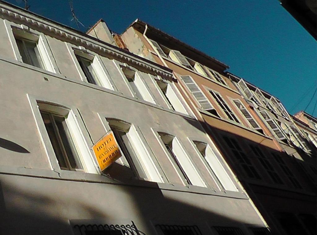 马赛文艺复兴酒店的白色的建筑,旁边有一个黄色的标志