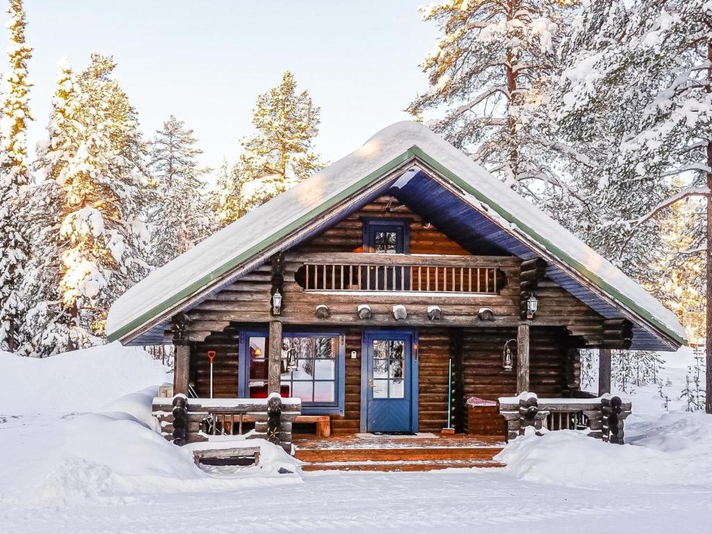 列维Holiday Home Tikkatupa by Interhome的雪中带蓝色门的小木屋