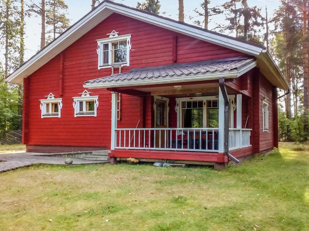 Juhanala瓦特拉卡维洛玛克斯库度假屋的红色的房子,前廊和窗户