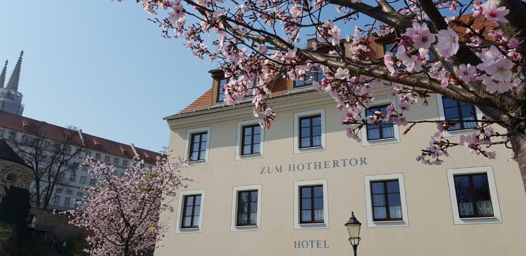 格尔利茨祖姆霍托特伽尼酒店的一座白色的建筑,上面有金色的角形酒店