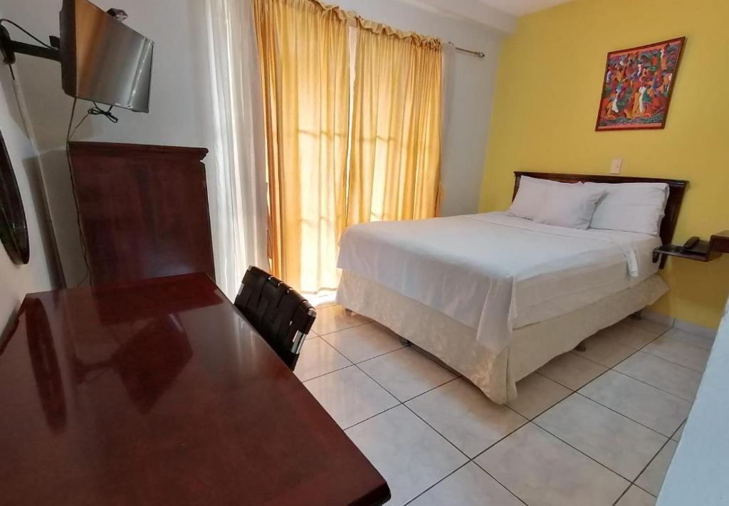 圣萨尔瓦多圣何塞旅馆的一间卧室配有一张床、一张桌子和一台电视