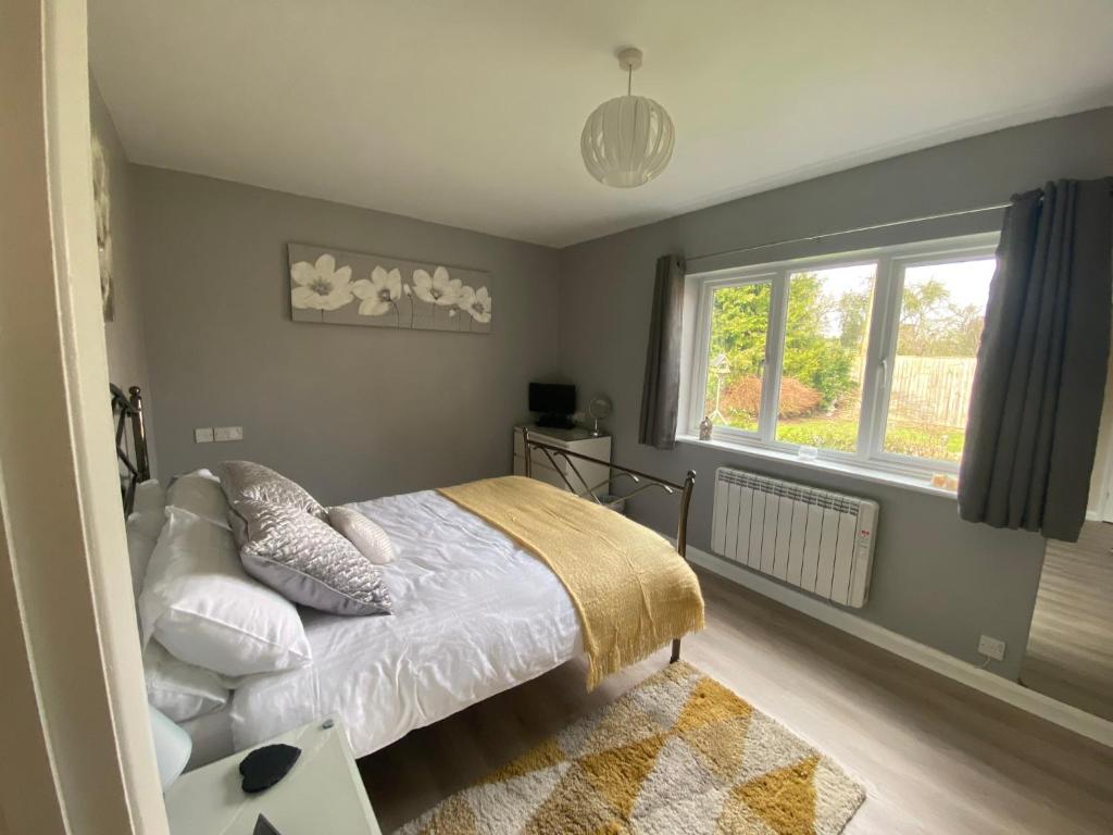 Manningford AbbotsEntire guest house, in Pewsey Vale, Wiltshire的一间卧室设有一张床和一个窗口