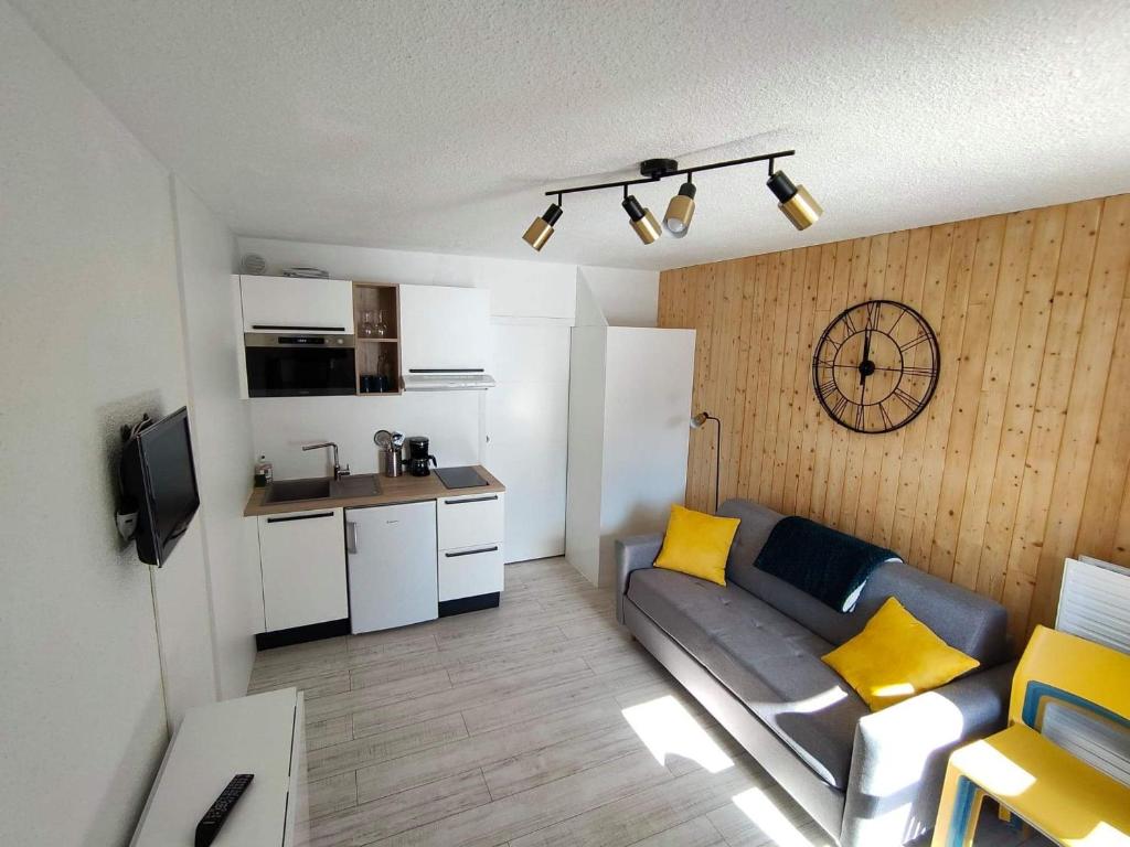 莱索尔Cocon d'altitude - Studio avec vue sur les pistes的带沙发的小客厅和厨房