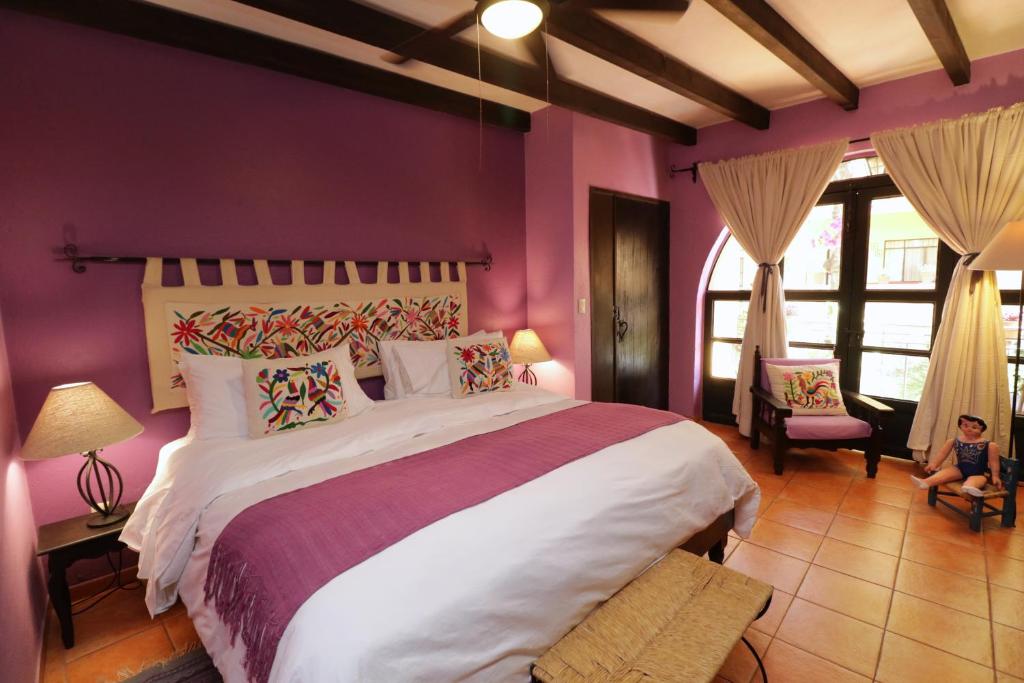圣米格尔-德阿连德卡萨米亚套房酒店的一间卧室设有一张紫色墙壁的大床