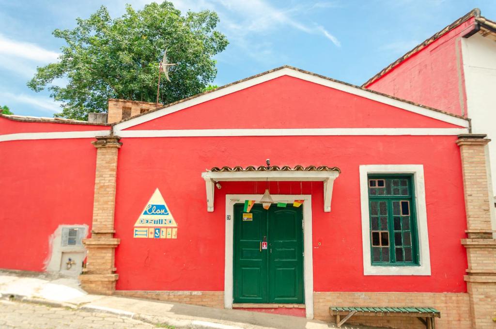伊利亚贝拉Clan.Destino Hostel的一座红色的建筑,设有绿门