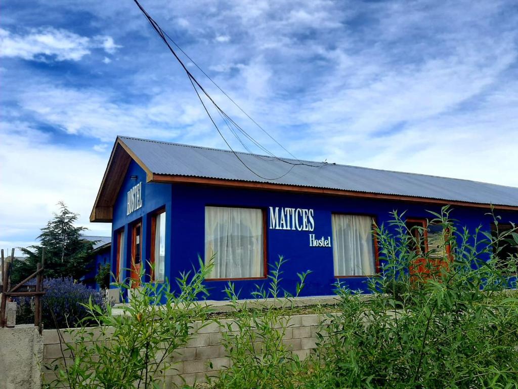 埃尔卡拉法特Matices Hostel Terminal的蓝色的建筑,旁边标有标志