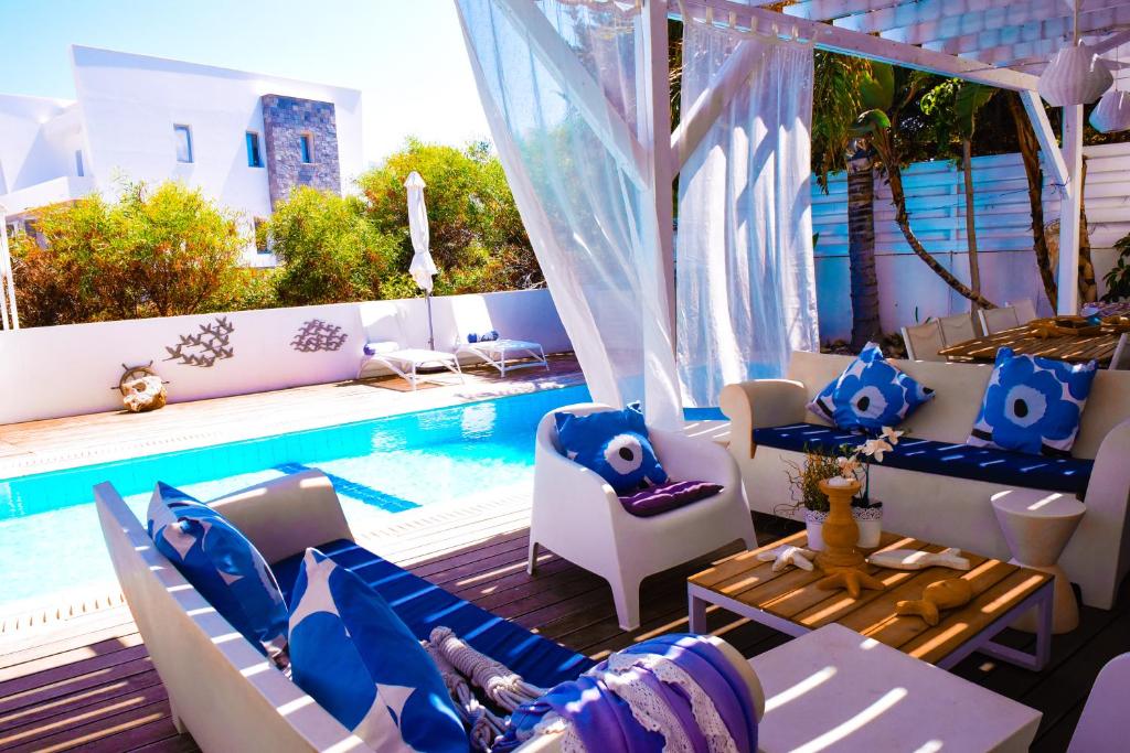 普罗塔拉斯Riverland beach villa的庭院设有游泳池、椅子和桌子。