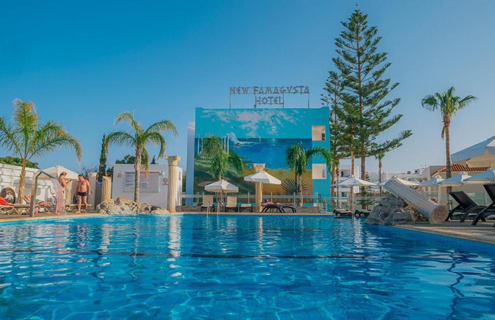 阿依纳帕New Famagusta Hotel & Suites的棕榈树度假村内的大型游泳池