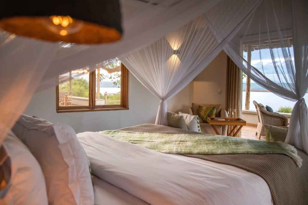 姆托瓦姆布Manyara's Secret的一间卧室配有一张天蓬床和窗户
