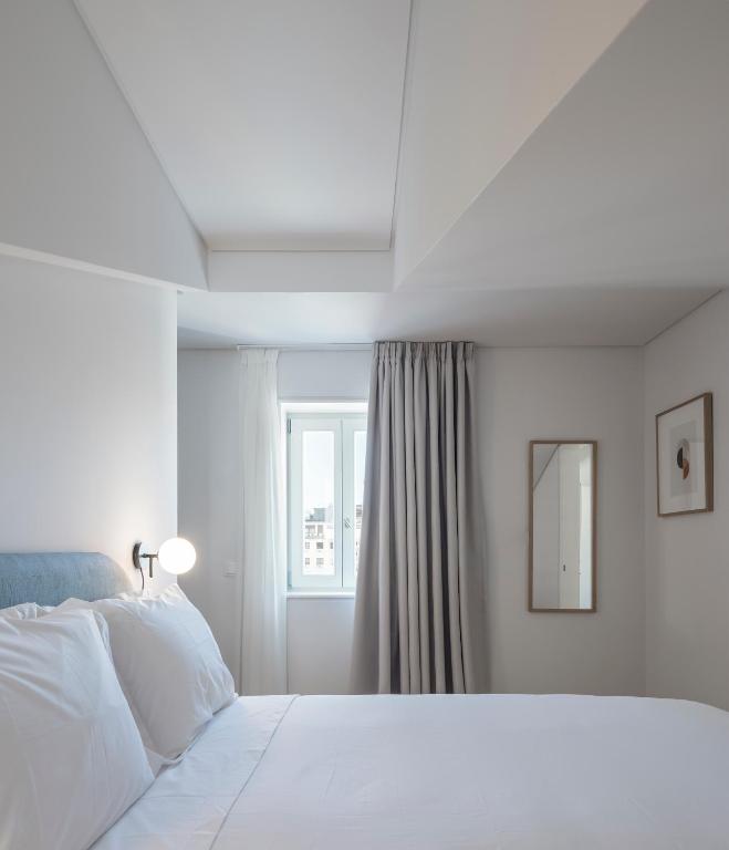 里斯本Lisbon Serviced Apartments - Mouraria的白色的卧室设有床和窗户