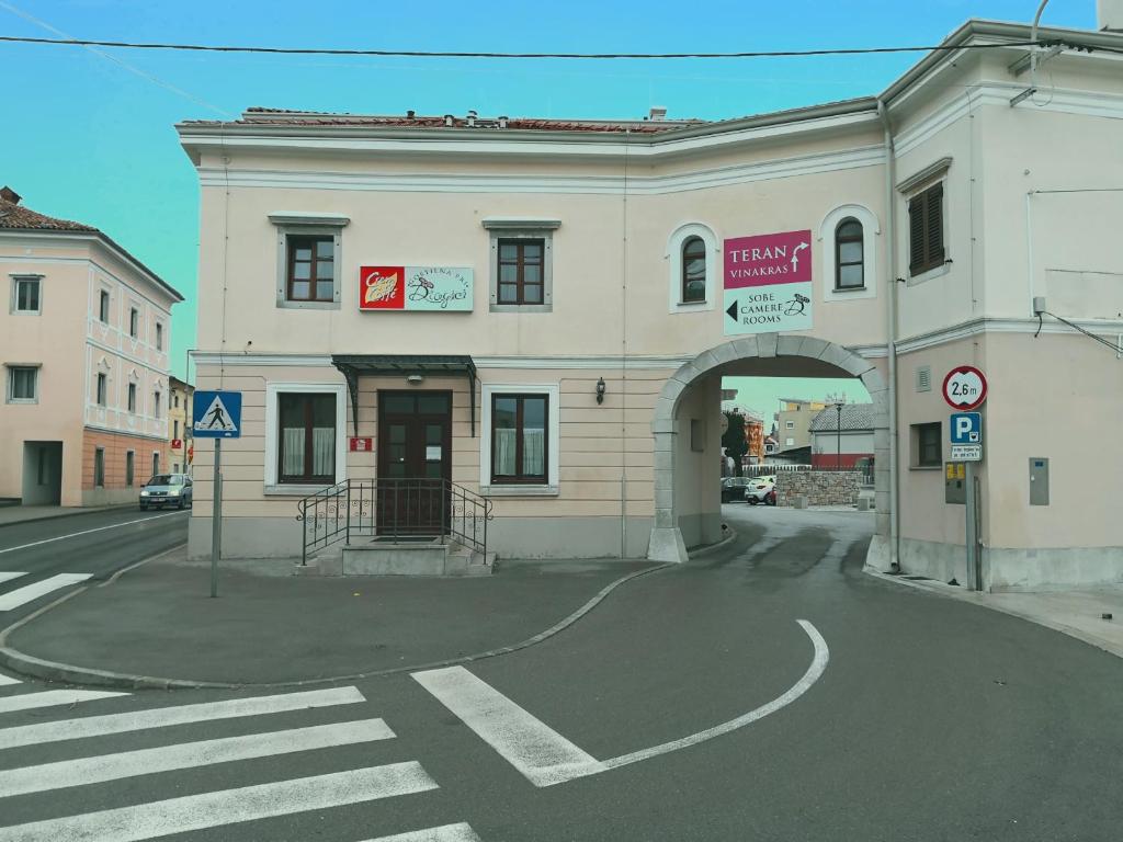 塞扎纳Gostilna pri Dragici, gostilna s prenočišči, d.o.o.的街道上一座带拱门的大型白色建筑