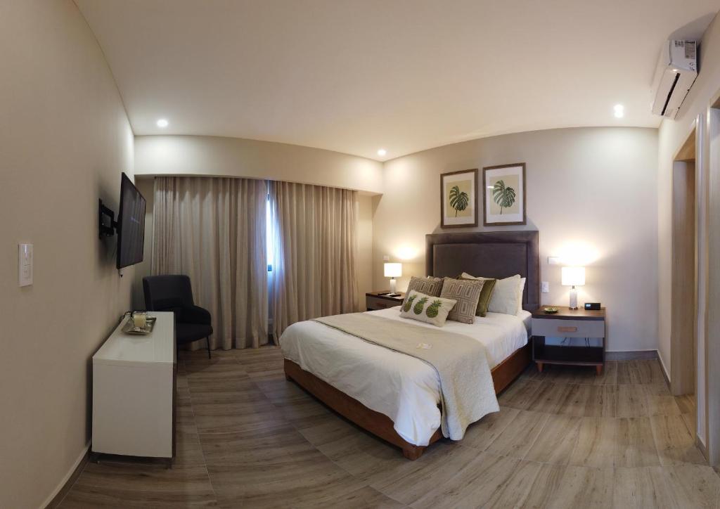 圣多明各Regatta Living Hotel By Mint的酒店客房设有一张大床和一张书桌。