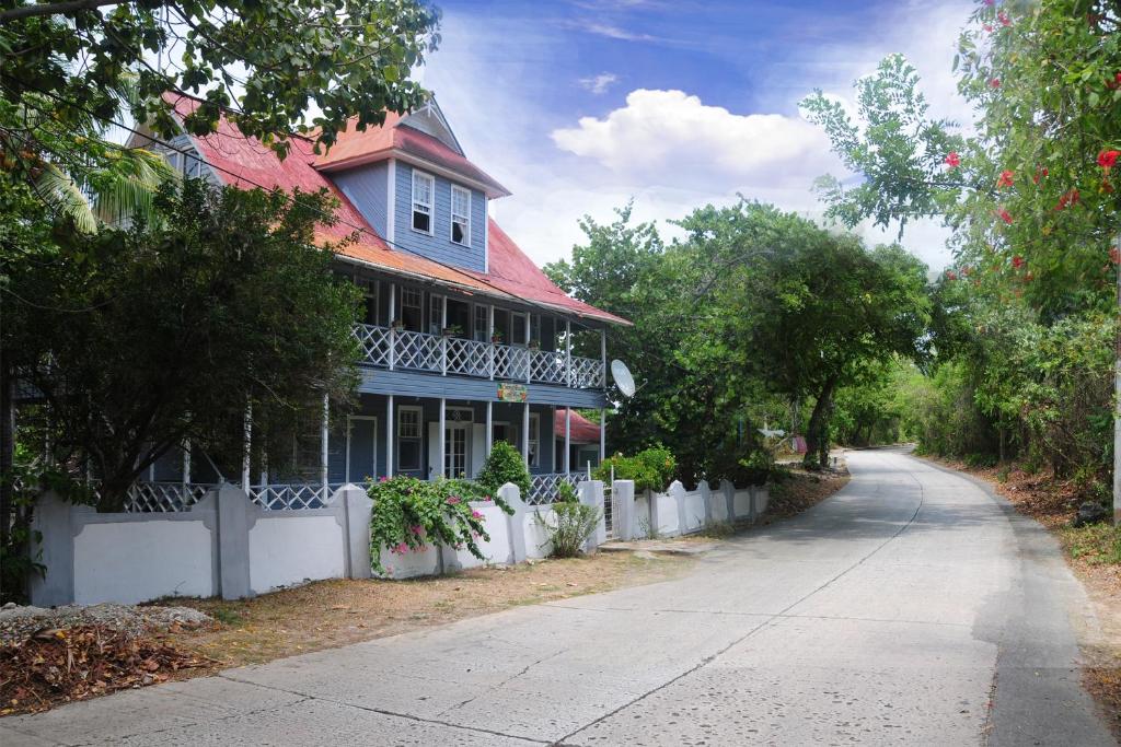 圣安德烈斯Coconut Paradise Lodge的一条街道旁的蓝色房子,有白色的围栏
