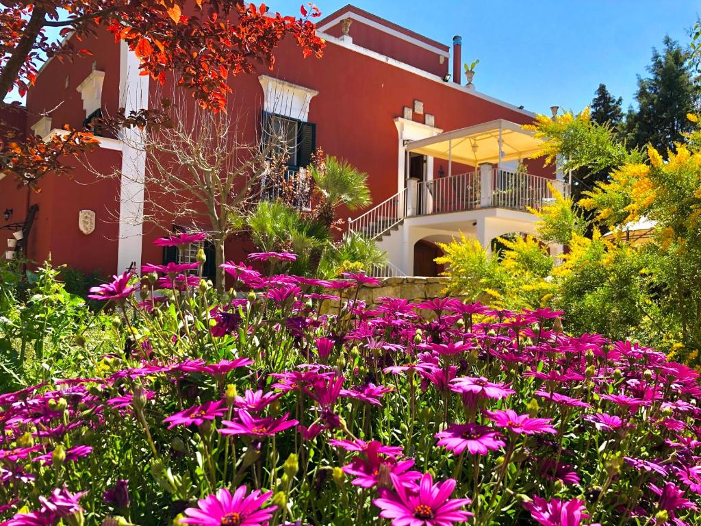 PadresergioAntica Masseria的一座花园,在房子前方种有粉红色的花朵