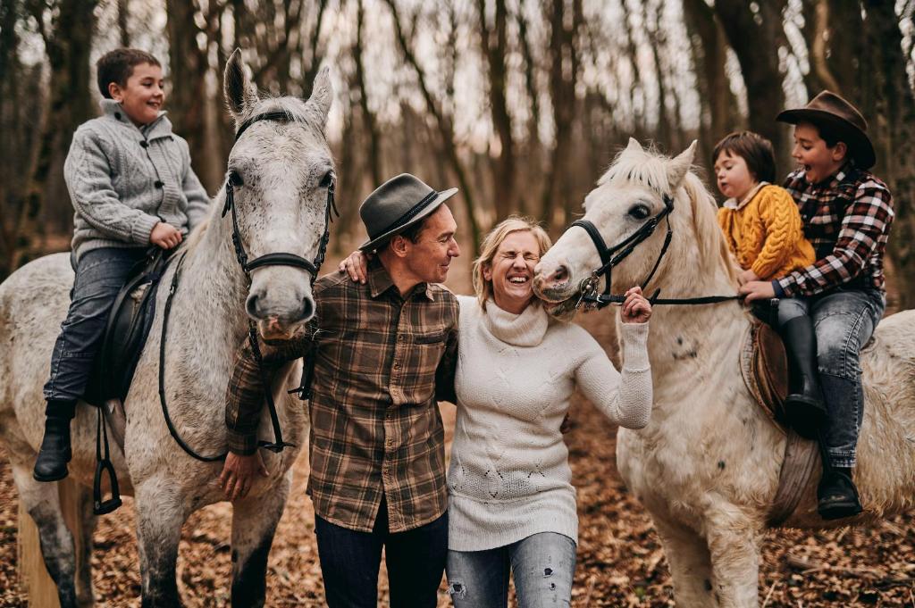 塞扎纳Tmbin's barn - nature, horses, family的一群在树林里骑马的人