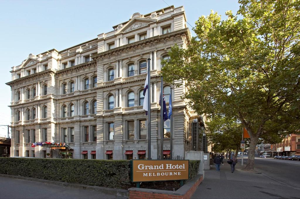 墨尔本Grand Hotel Melbourne的前面有标志的大型白色建筑