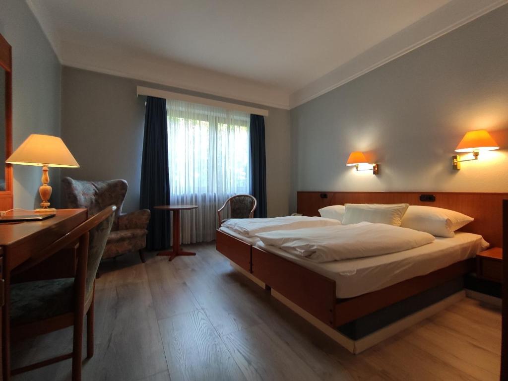 汉堡Condi Hotel的酒店客房配有一张床、一张书桌和一张书桌。