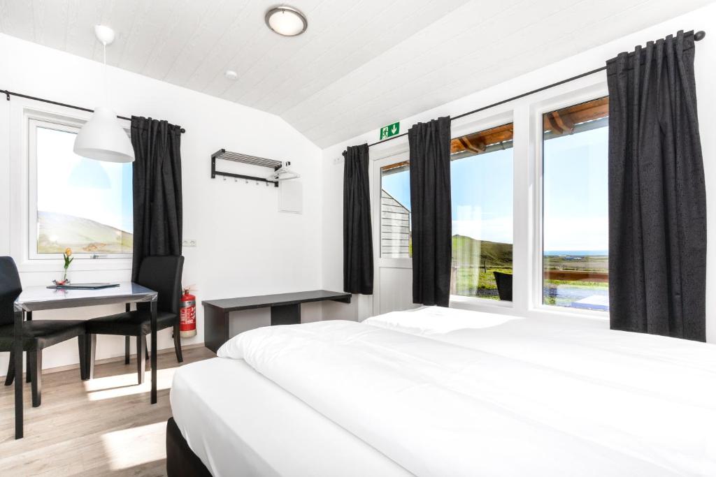 维克瓦姆波尔宾馆的卧室配有一张床、一张书桌和窗户。