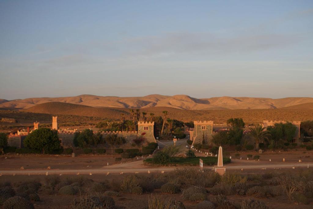 盖勒敏Complexe touristique FORT BOU-JERIF的沙漠中的一座小镇,以群山为背景