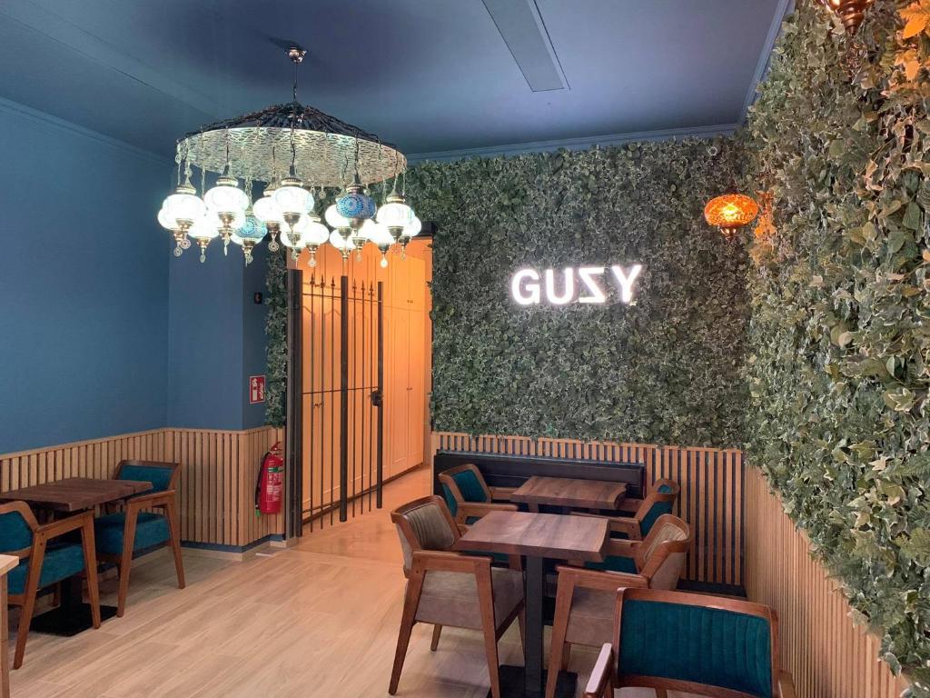 利尔Hotel Guzy的一间设有桌椅的餐厅,墙上有罪名
