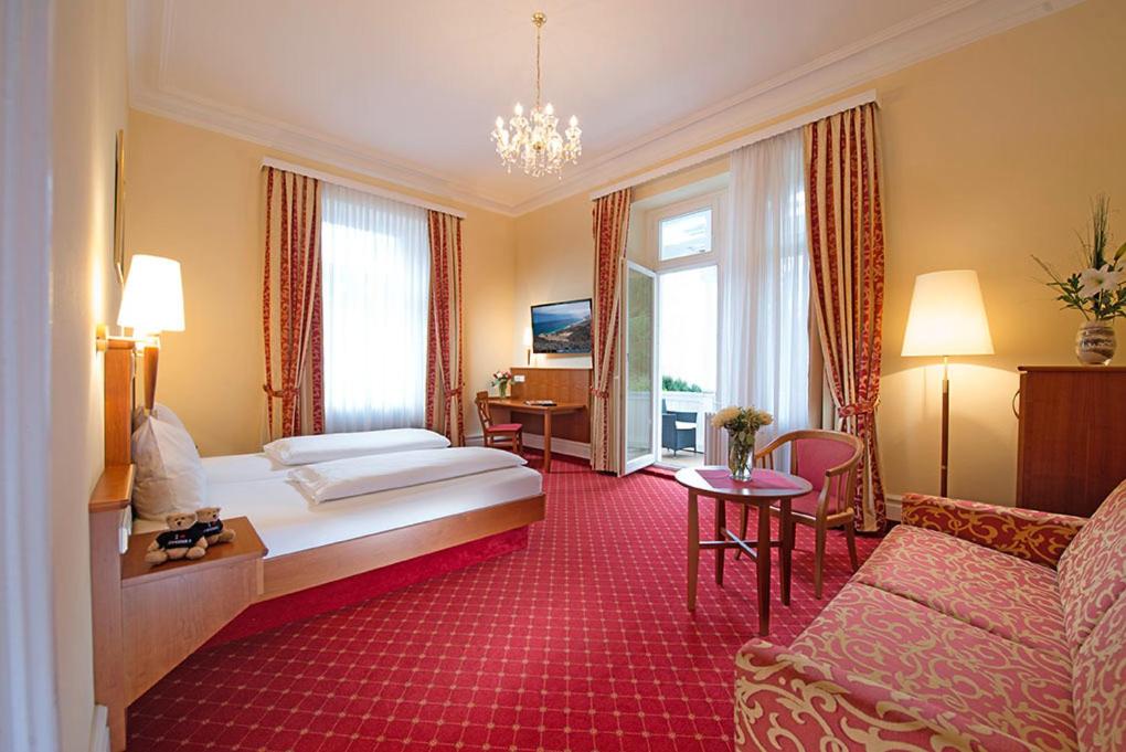 巴登-巴登施韦策霍夫高级酒店的酒店客房,配有床和沙发